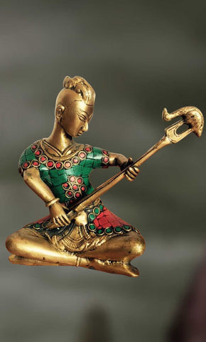 Brass-Stone sculpture of man playing long musical pipe  