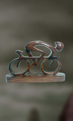 Wood sculpture of a man cycling